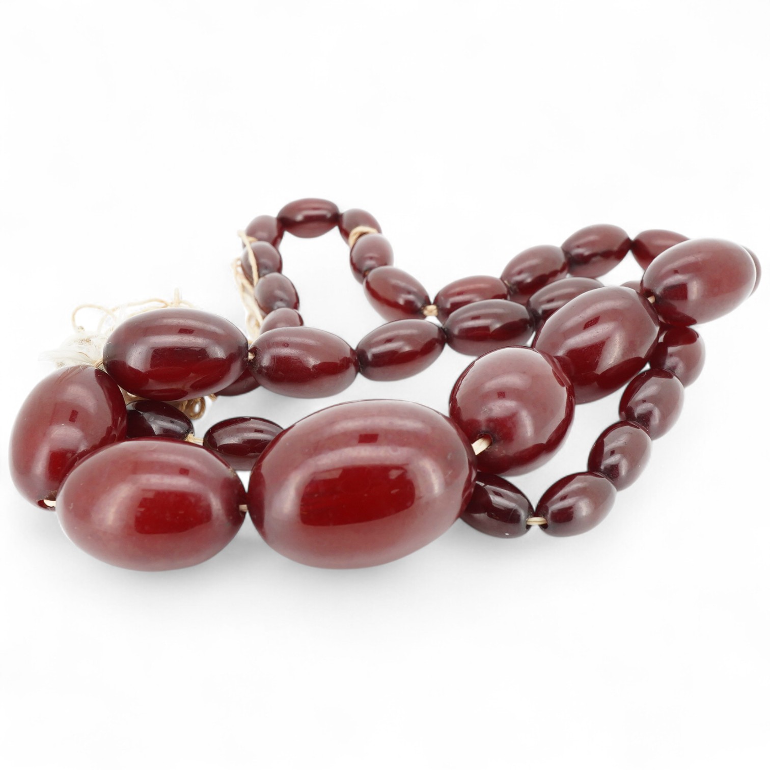 A cherry-coloured bakelite imitation amber necklace, composed of graduated oval beads measuring approximately 1.2-3cm, length 56cm, gross weight approximately 54 grams